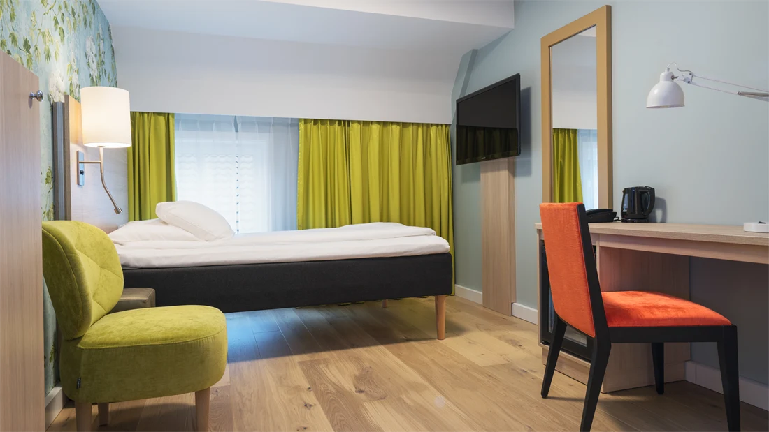 Skrivebord, stol, seng og smart-TV i enkeltrom på Thon Hotel Tønsberg Brygge