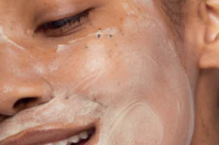 Et smilende dameansikt med ansiktsmaske