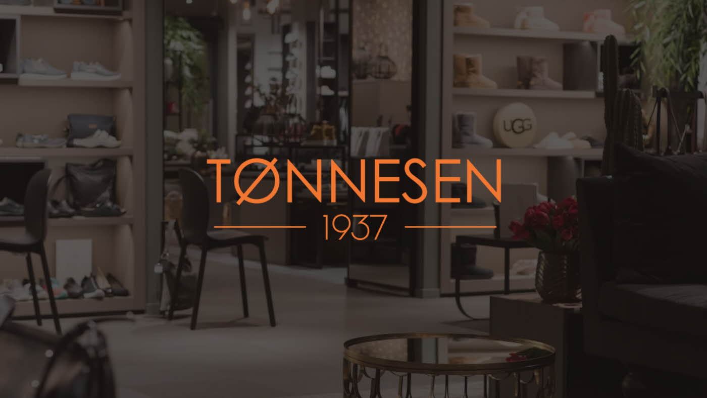 Bilde av en butikk i bakgrunnen, med logoen til Tønnesen 1937 på midten