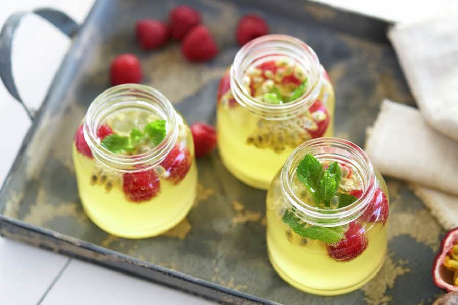 Glass med sommerdrikk som inneholder pasjonsfrukt