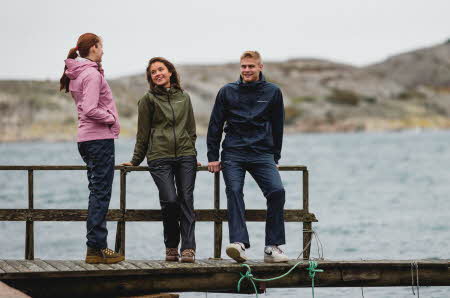 tre personer med regntøy i diverse farger