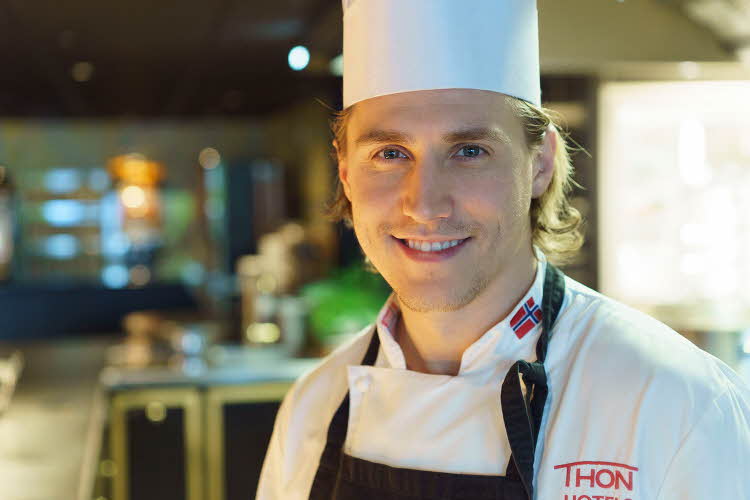 Kjøkkensjef Simon Johannessen smiler på kjøkken på Thon Hotel Bergen Airport