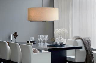 Bilde av en taklampe som henger over et spisebord med glass og tallerkener.