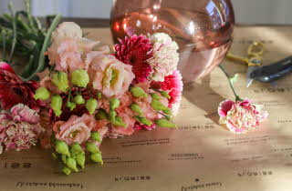 Rosa blomster og en rosa gjennomsiktig vase