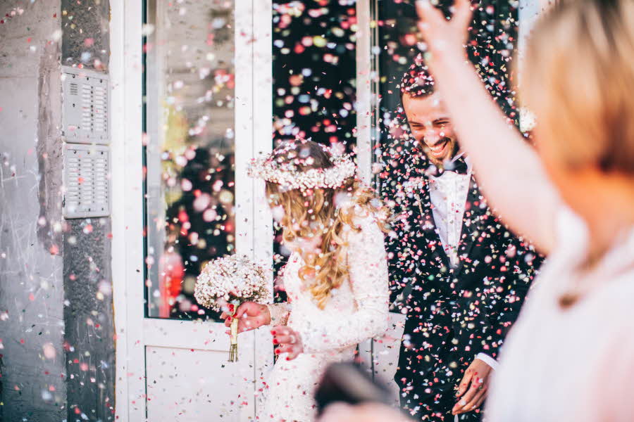 Nygift par blir kastet konfetti på
