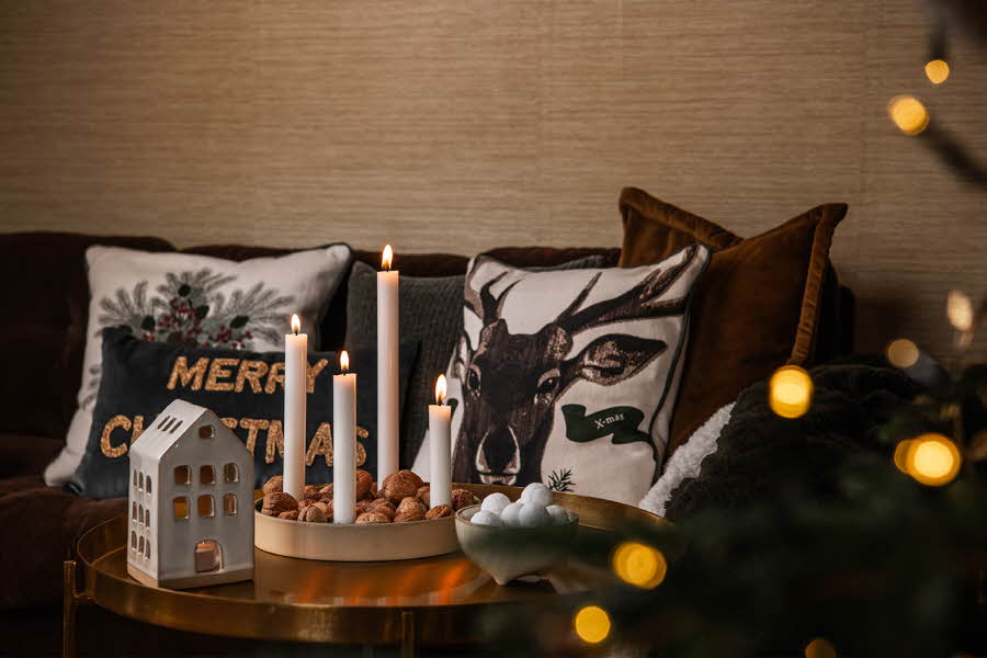 Stue med lysestake og pynteputer med julemotiv