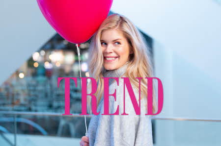 Dame som holder ballong og smiler og logo til Trend