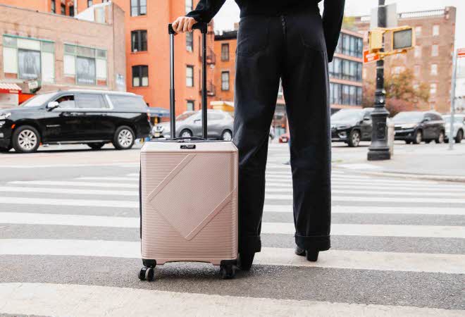 En kvinne krysser fotgjengerfelt med koffert fra Morris