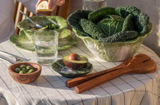 Et bord dekket med grønn salat, avocado og oliven.