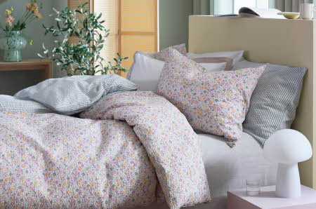En seng med blomstrete sengesett