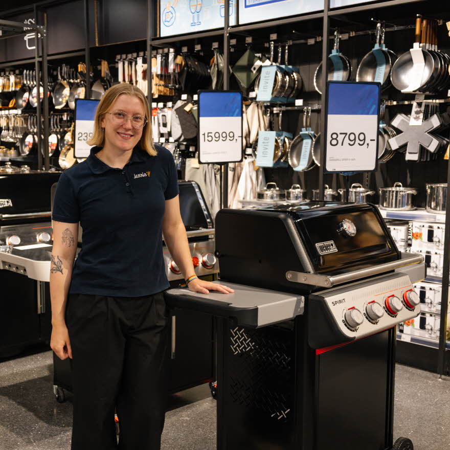 dame står ved grill i butikk