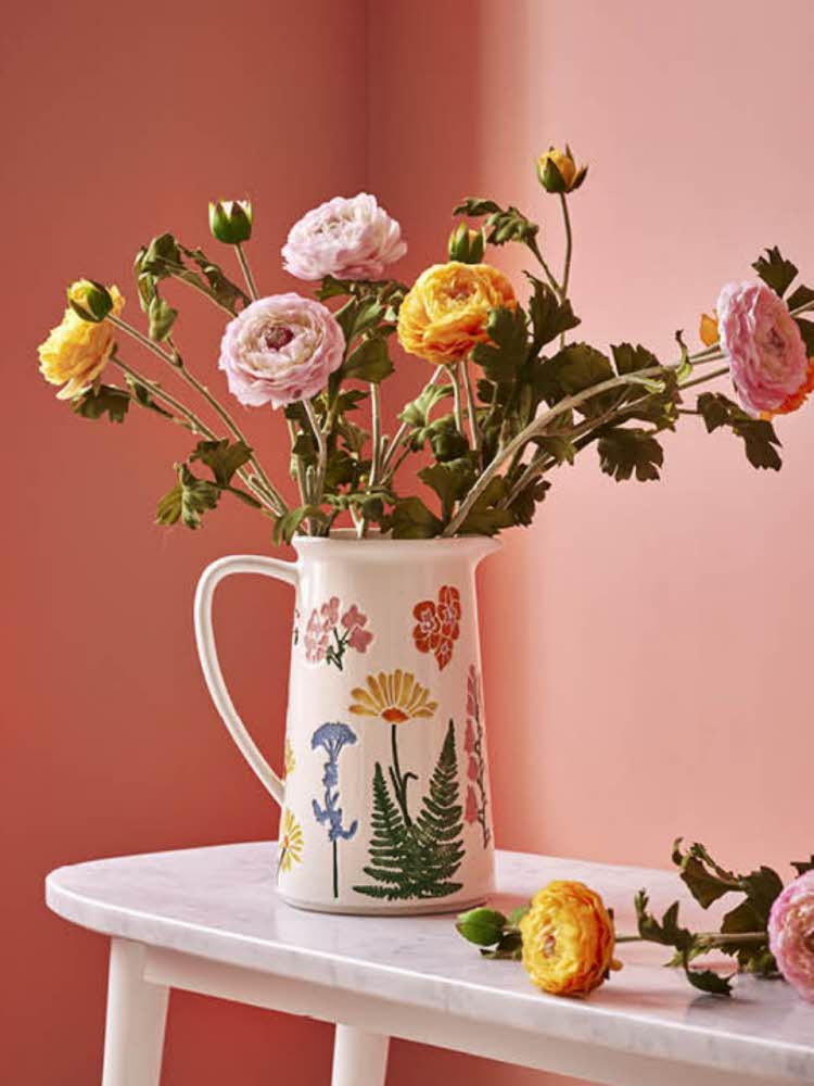 Blomstret kanne med blomster