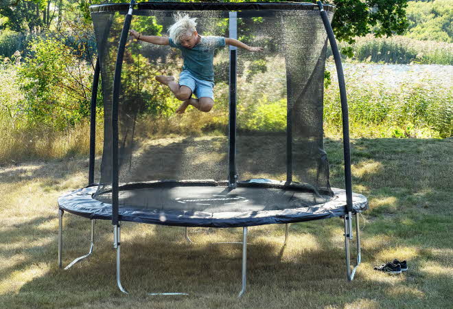 Gutt som hopper på en trampoline.