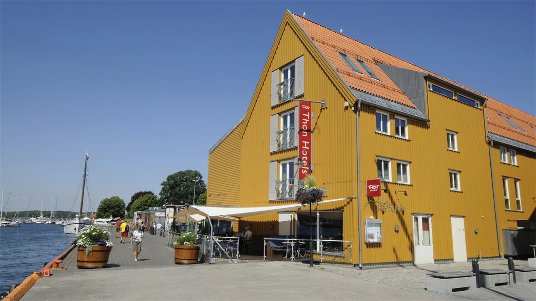 Fasaden til Thon Hotel Tønsberg Brygge med gule vegger og plassering på Brygga i Tønsberg sentrum