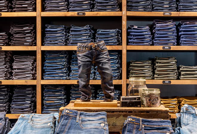 hyller og bord med masse jeans i utstilling
