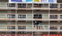 Fasaden av Kjøpmannsgata 15 i Trondheim, retning Nidelva. Fasaden er dekket med stillaser og kledningen er i ferd med å byttes. Skilt med Thon Eiendom, Consto m.fl. henger på.