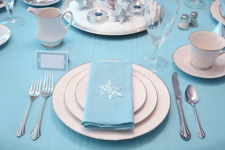 Dekorert bord og kuvert med blå duk og blå serviett. Foto til artikkel om ting å huske på når du skal arrangere konfirmasjon.