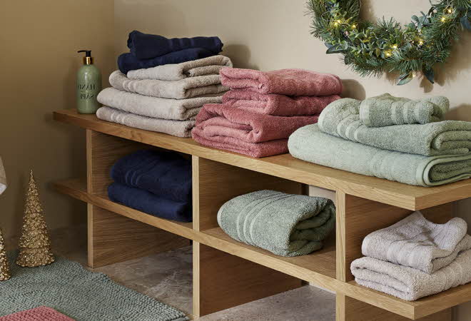 En lav hylle med håndklær og badematter