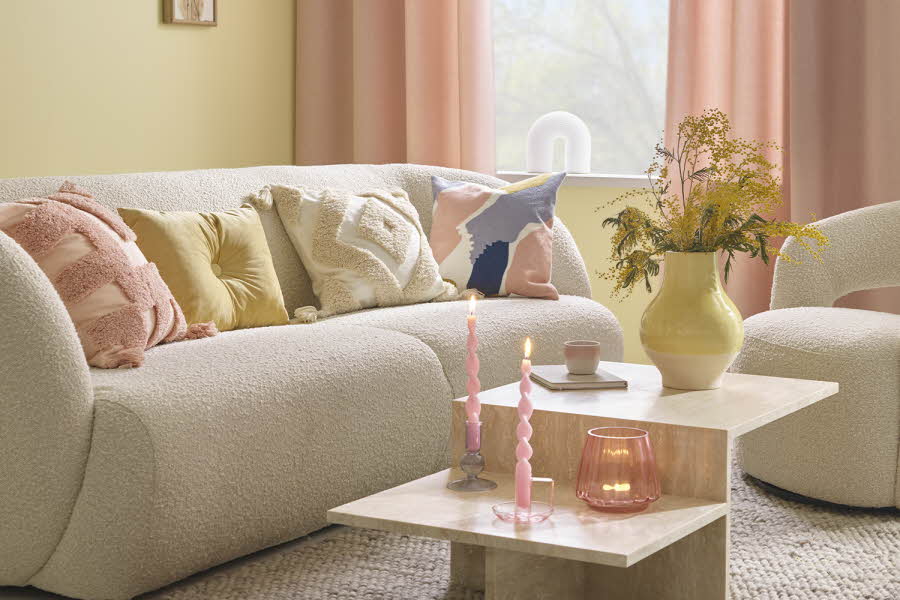 Sofagruppe med puter og rosa gardiner