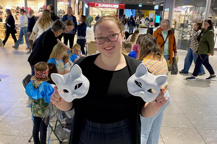 Jente som holder frem hvite kattemasker som kan males