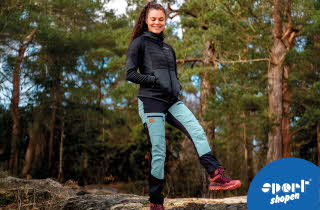 Dame i turklær står i en skog.