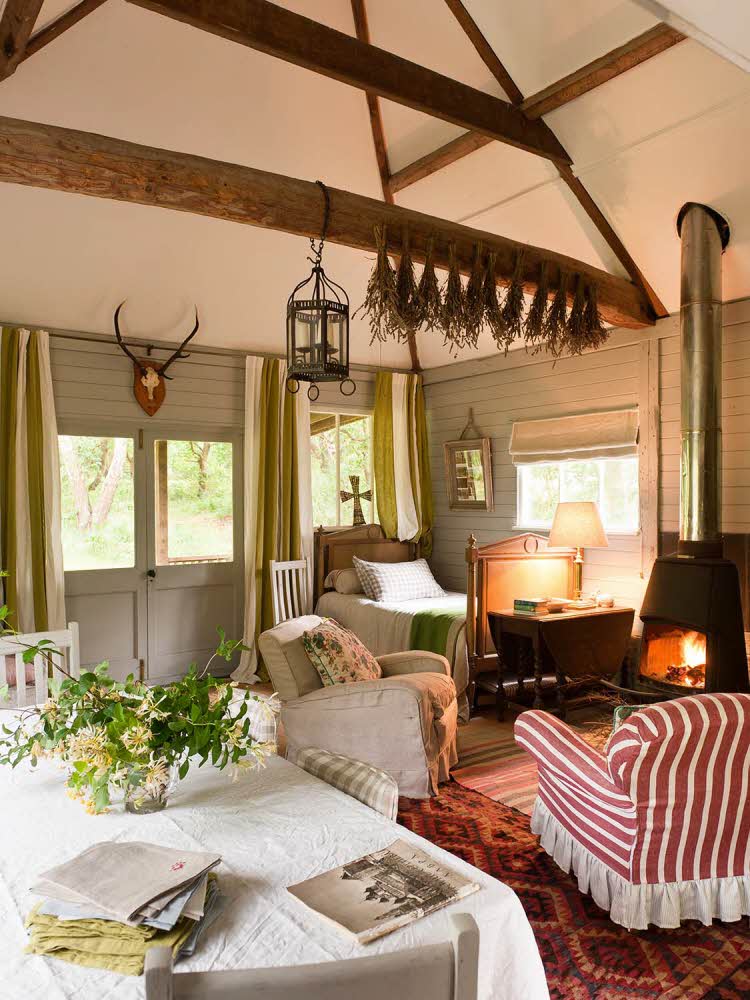 Stue i et koselig hus med fyr i peisen og gamle lenestoler i en miks av mønstre