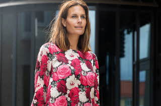 Dame iført langermet topp med stort blomsterprint i rosa, rødt og hvitt.