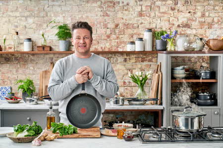 Jamie Oliver som holder en stekepanne inn på et kjøkken