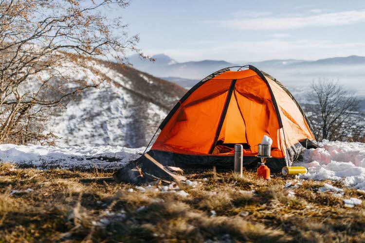 Oransje telt med leirplass i delvis snødekt landskap