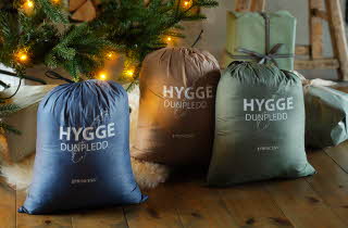 En blå, en beige og en grønn bag med Hygge dunpledd.