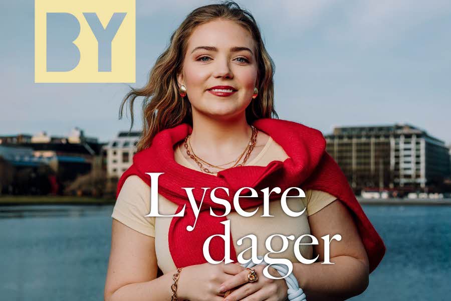 vårbilde-fra-bergen-med-en-smilende-blond-ung-dame-med-rød-genser-over-skuldrene-og-beige-t-skjorte