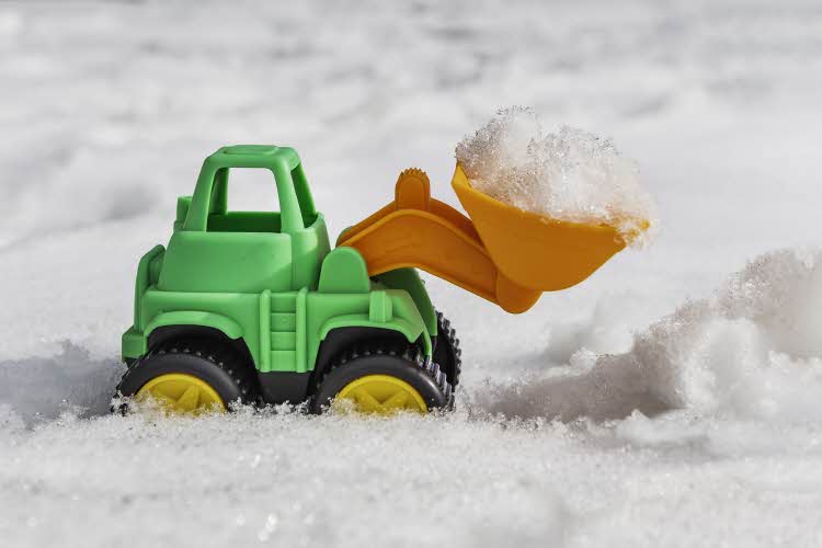 Leketraktor i snøen med skuffen full av snø