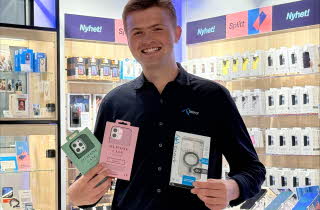 Mann fra Telenorbutikken holder deksler til mobiltelefon