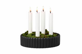 Sort, rund lysestake med fem hvite stearinlys og grønn mose.