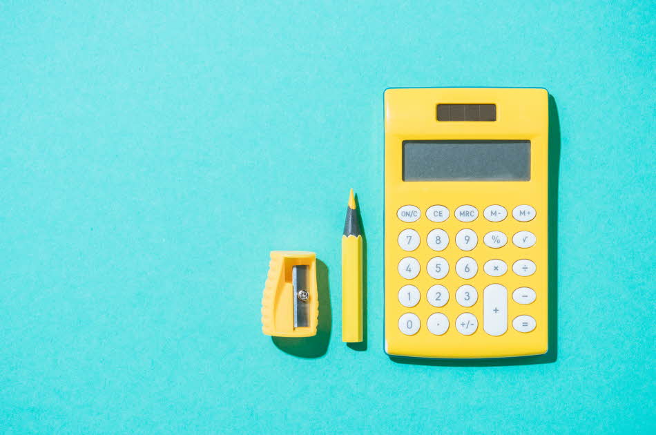 Flat lay av kalkulator, penn og blyantspisser i gult