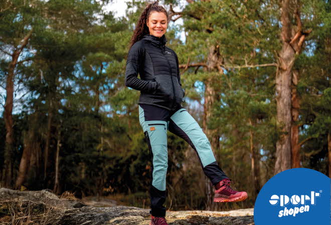 Dame i turklær står i en skog.