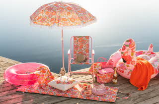En brygge med solstol, parasoll, badering, håndkle og kjølebag i samme mønster og farge
