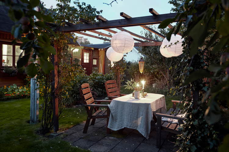 Pergola med sittegruppe og lamper kveld