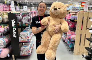 Dame som holder stor teddybjørn