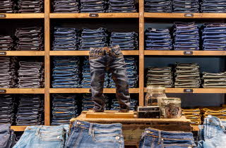 hyller og bord med masse jeans i utstilling