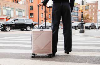 En kvinne krysser fotgjengerfelt med koffert fra Morris