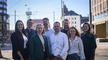 Fotografi av prosjektgruppen. 8 personer står på gaten