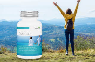 Person på en gresskledd høyde med en Omega-3 flaske fra Sunkost.