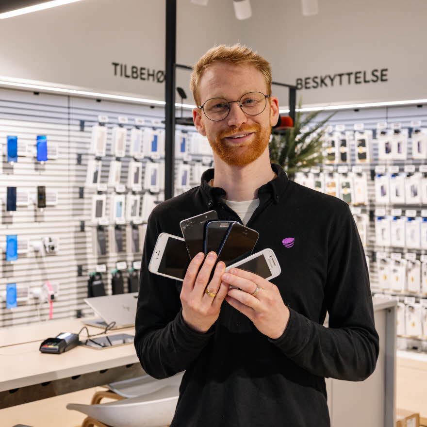 mann holder brukte mobiler i telia butikken