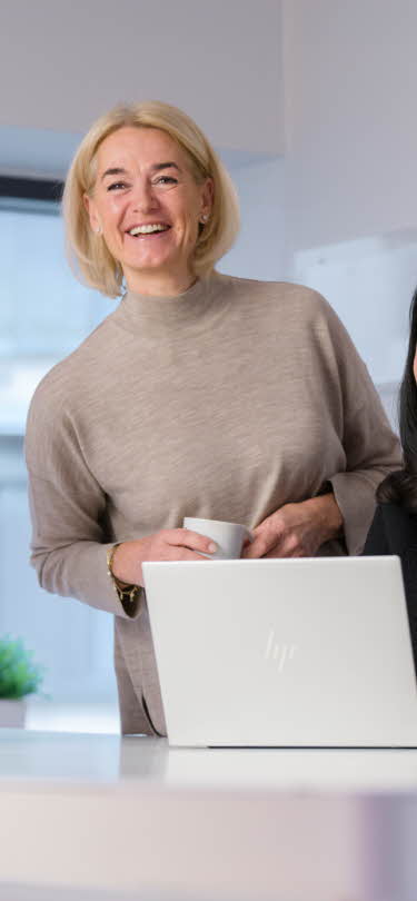 En person som står foran en bærbar datamaskin