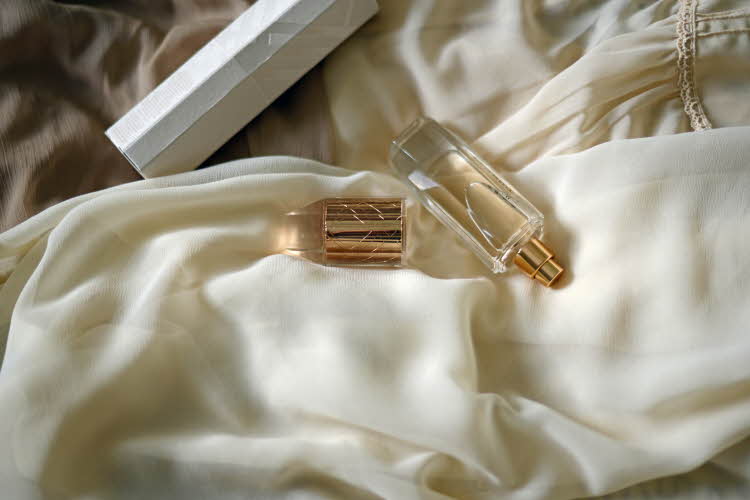 Parfymeflaske på beige mykt underlag