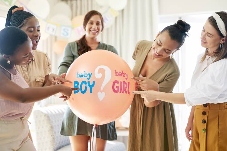 damer som peker på en ballong som står baby gutt eller baby jente