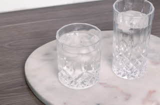 To glass med vann, et kort og et høyere, som står på en marmorplate
