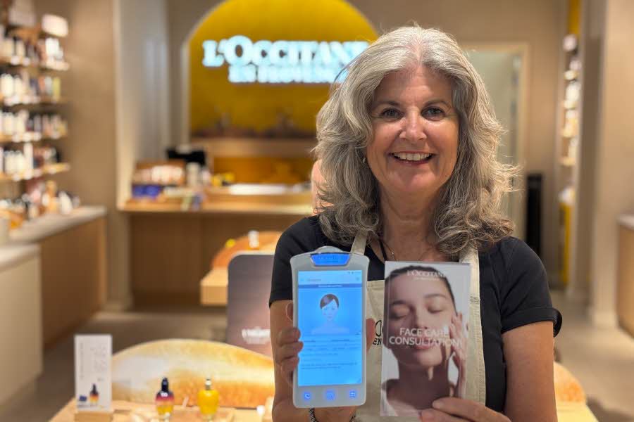 Dame fra L'Occitane viser frem face scanner