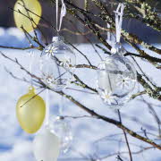 glassegg i gul, hvit og gjennomsiktig med blomstrer malt på som henger på kvister